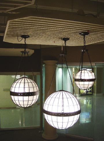 Ceiling cloud grid supporting a group of globe pendant lights