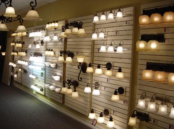 Showroom wall displaying rows of illuminated vanity fixtures and wall sconces